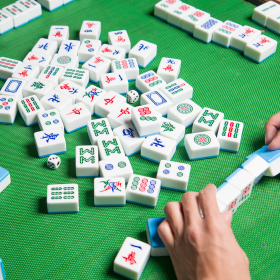  A player arranging mahjong tiles on a green felt board