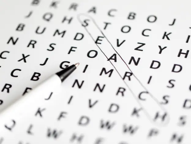 A closeup of a pencil and paper word search in progress 