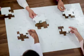 Multiple people completing a jigsaw puzzle